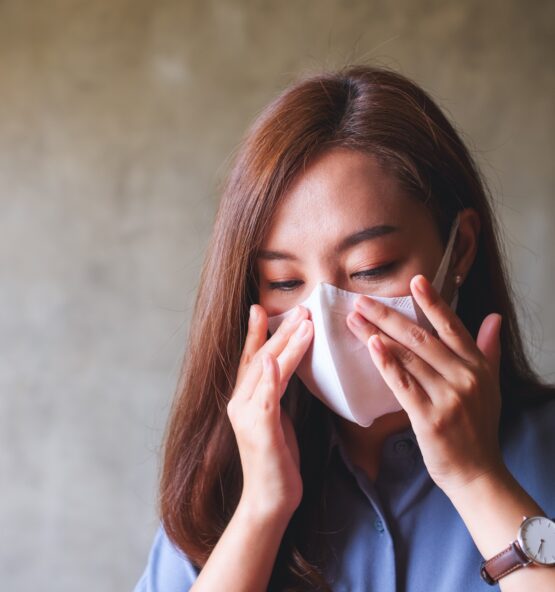 An asian woman putting on protective face mask for Healthcare and Covid-19 concept