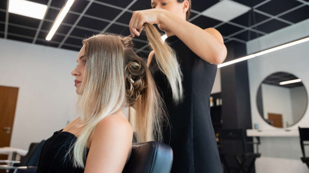 Hair stylist creating an elegant hairdo for a client in a modern salon